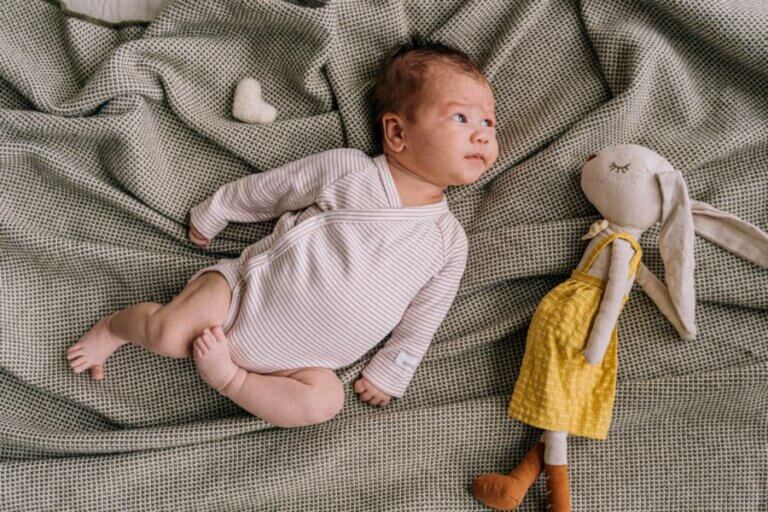 Baby mit Kuscheltier – Umweltzeichen helfen bei der Einordnung von Öko-Windeln