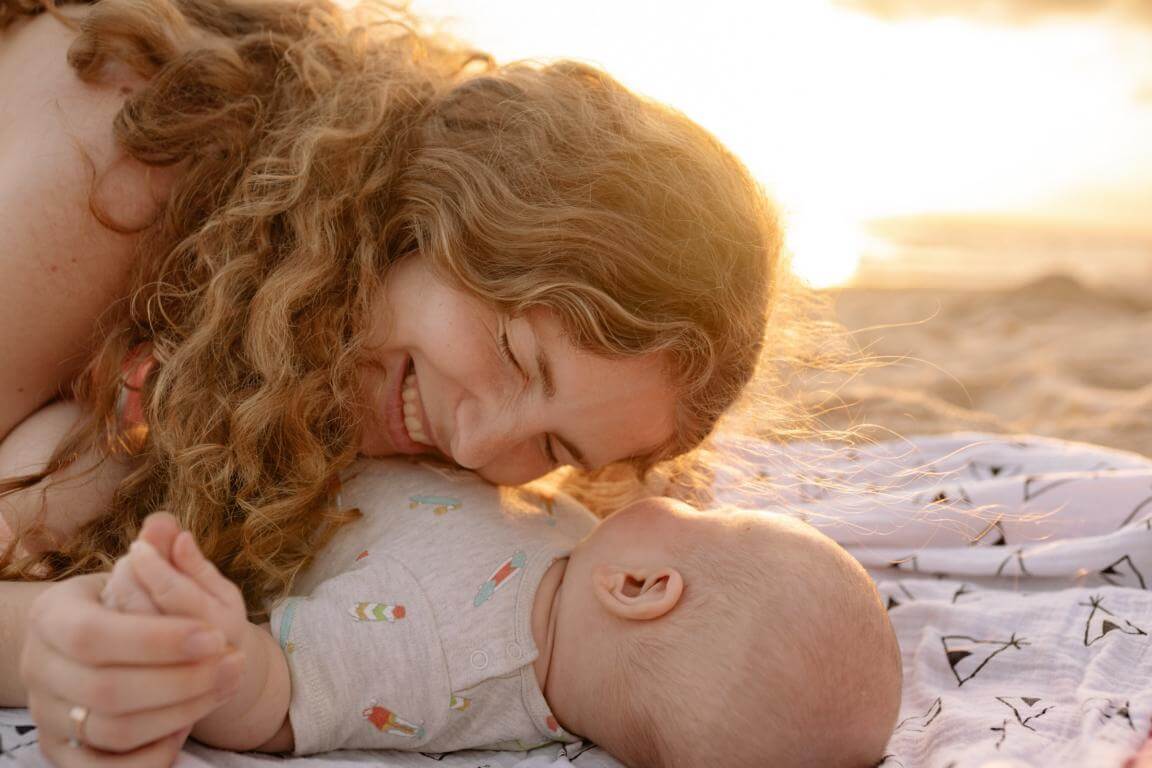 Frau mit Baby am Strand