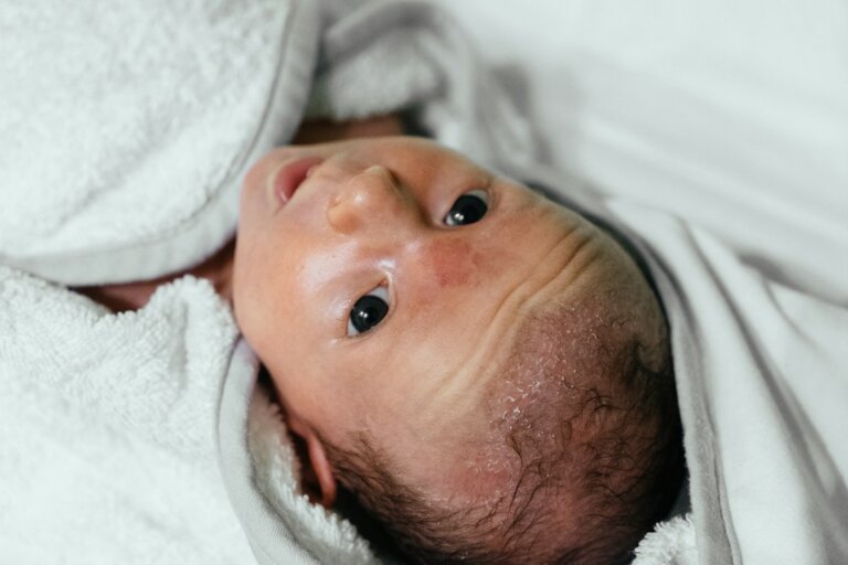 Baby unter einer weichen Decke als neutrales Motiv zu Wundschutz und gereizter Babyhaut