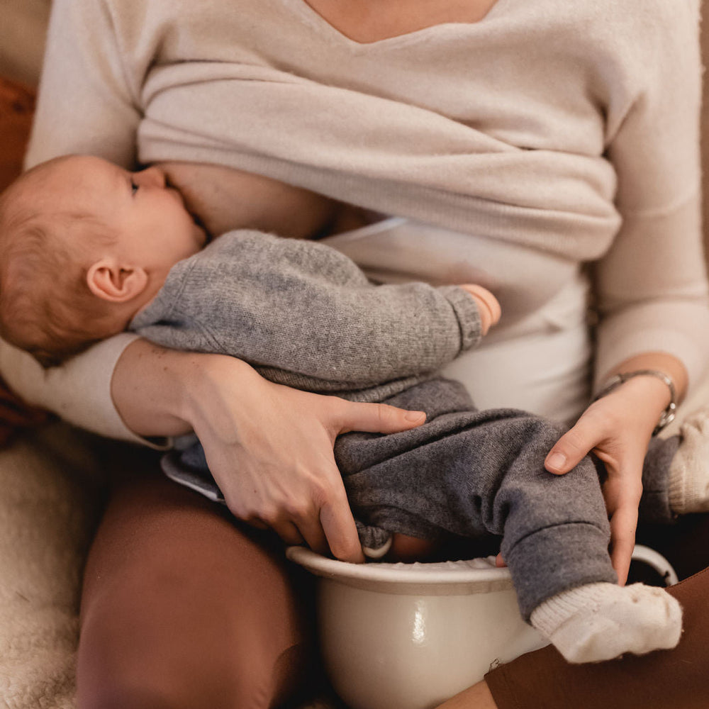 Baby wird in einer ruhigen Abhalteposition von einem Erwachsenen gehalten
