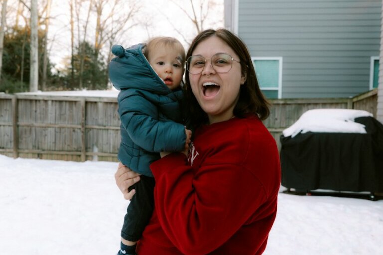 Mutter und Baby in warmer Winterkleidung im Schnee