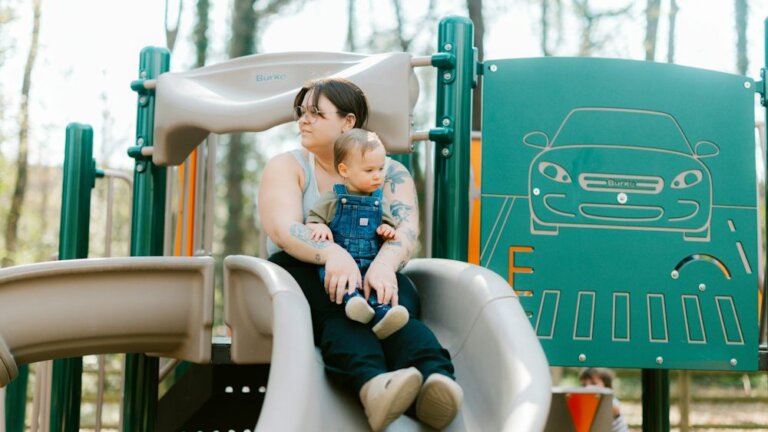 Mutter und Kind gemeinsam auf einem Spielplatz im Park