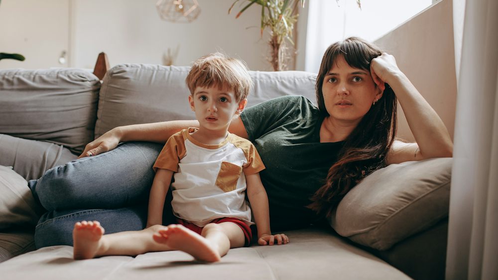Elternteil und Kind ruhen gemeinsam zuhause während einer Krankheitsphase