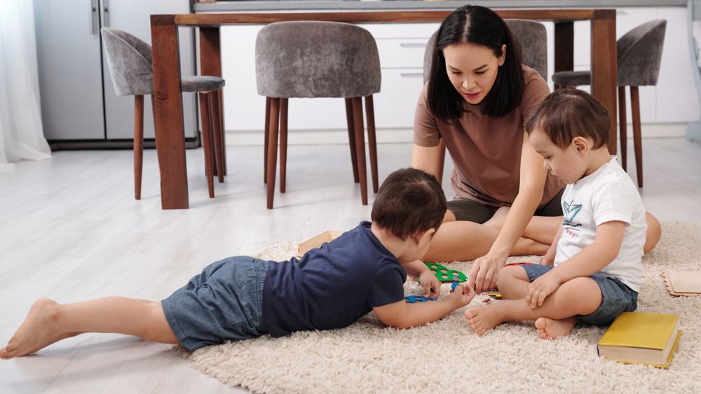 Mutter spielt zuhause mit zwei Kindern